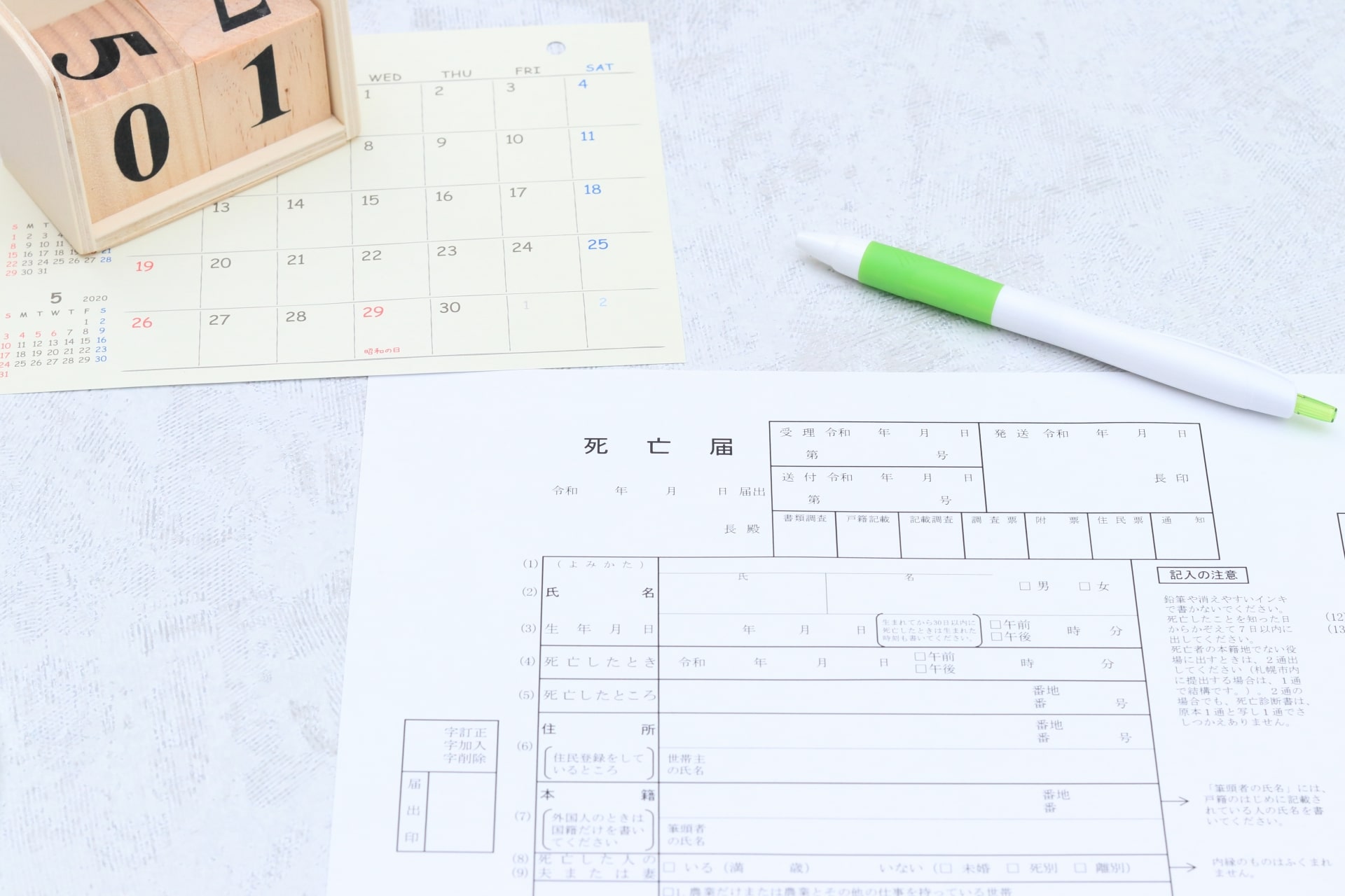 死亡届の書き方に迷うご遺族の机の上のイメージ