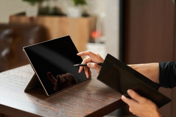 タブレット型POSレジで会計作業をする人の画像
