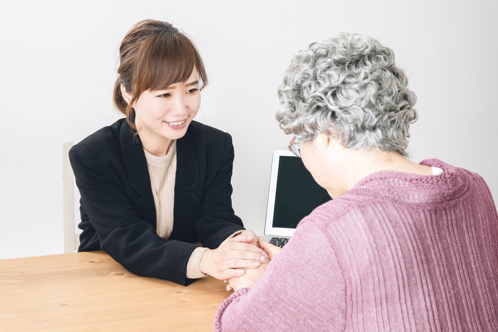 高齢女性に終活の相談をしてもらい、励ます終活カウンセラーのイメージ