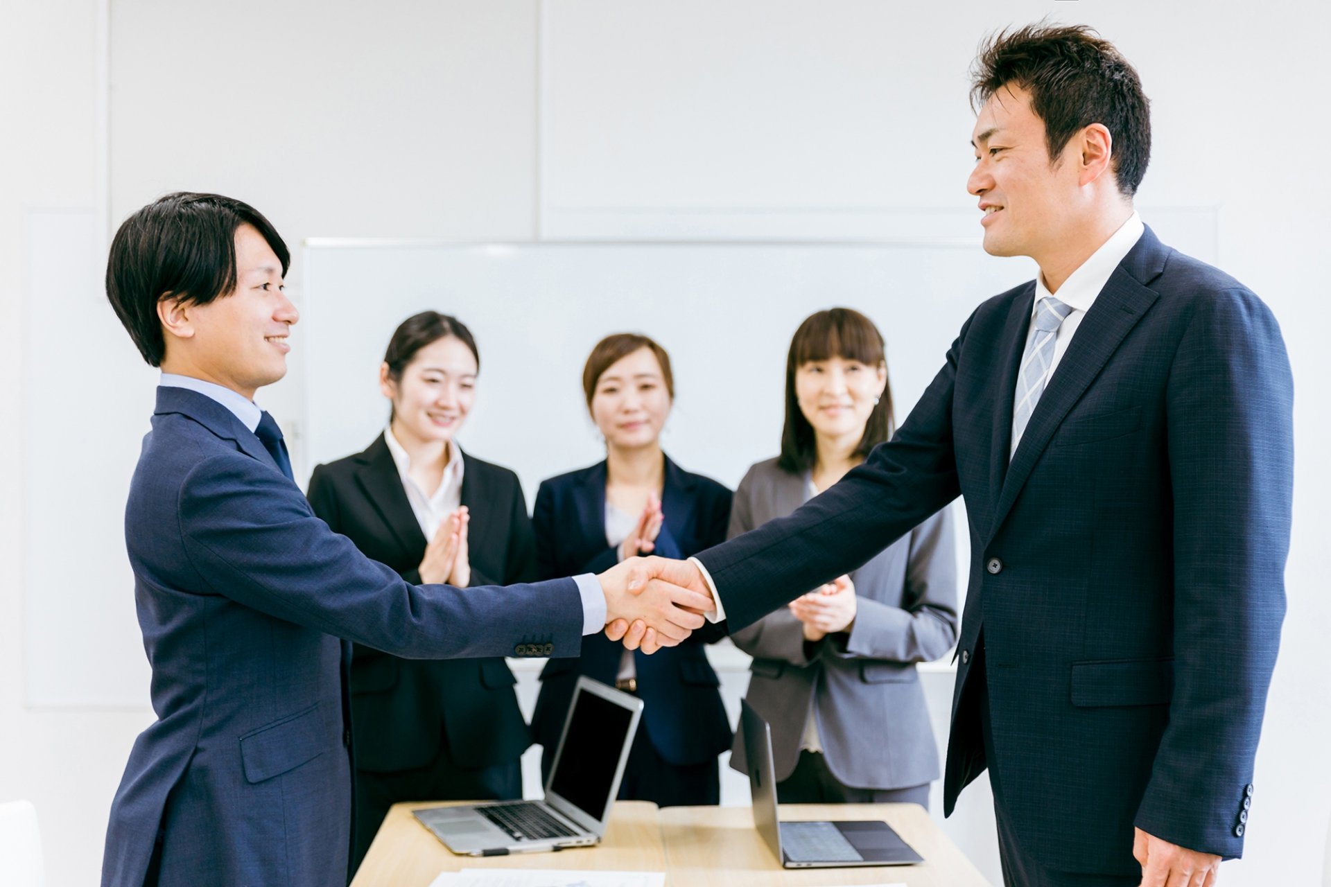 グリーフケア士認定資格に合格した社員を祝福する葬儀社社員のイメージ
