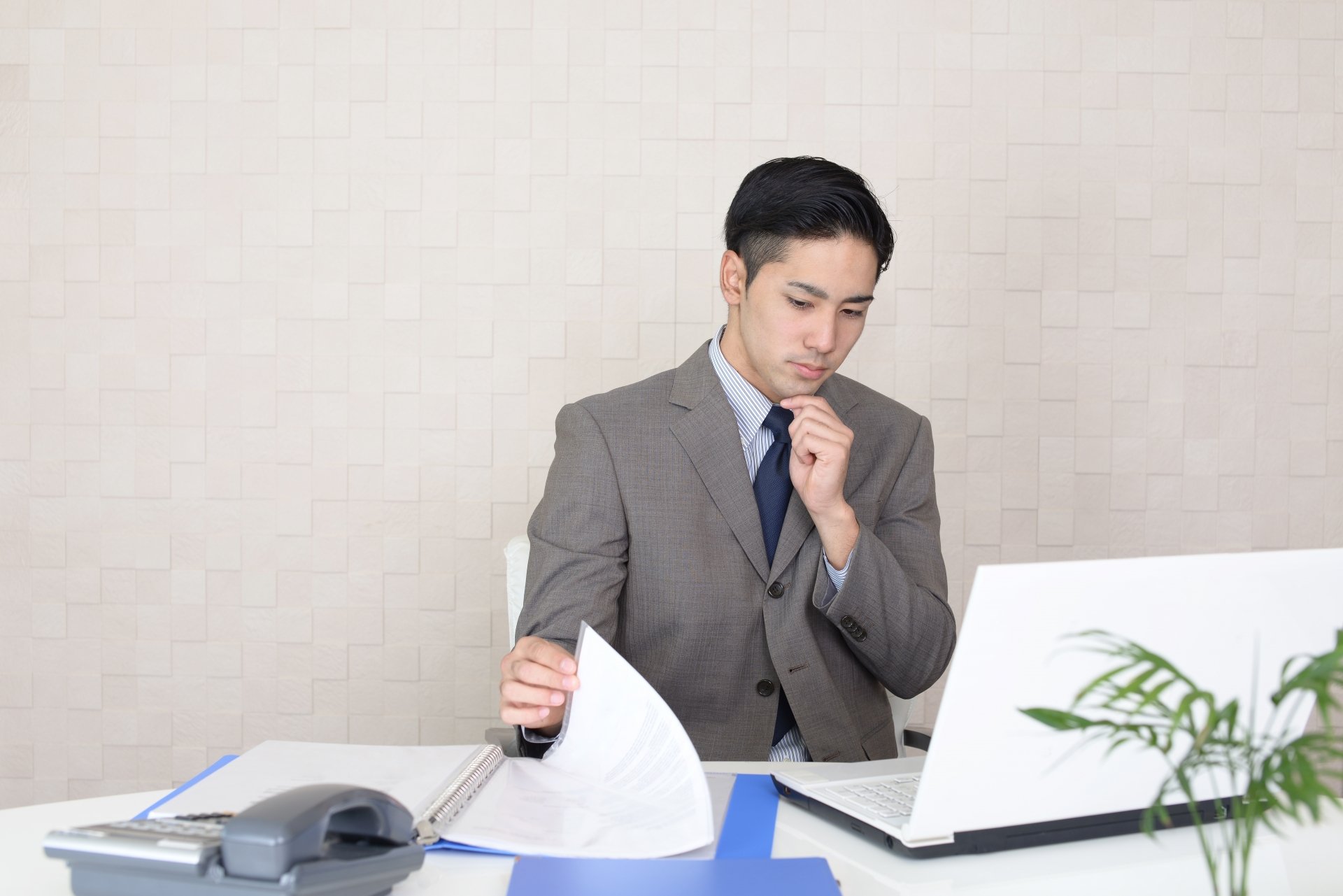 サジェスト対策について資料を請求して調べる墓石会社社員のイメージ
