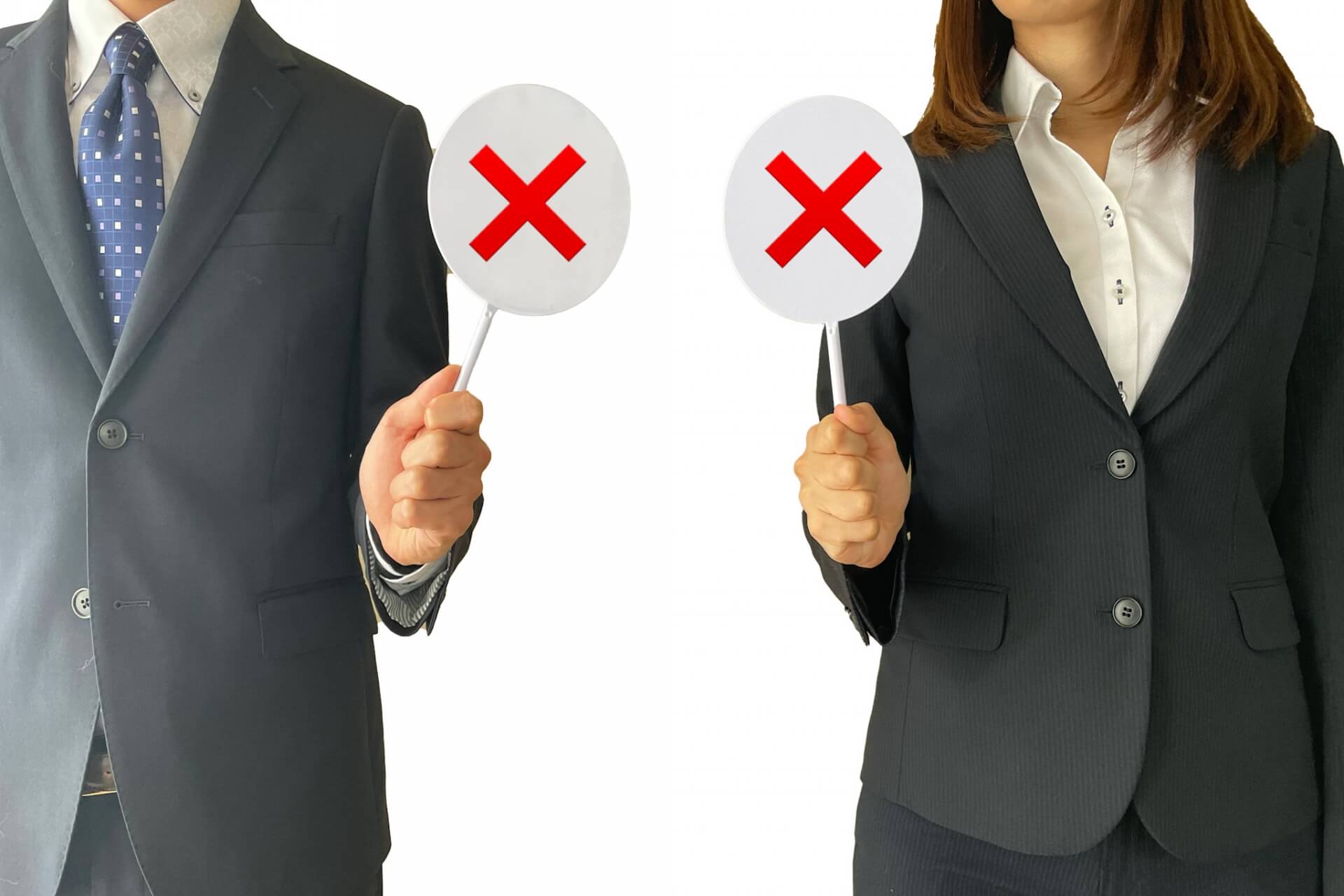 バツの札を持つ葬儀社男性・女性社員のイメージ