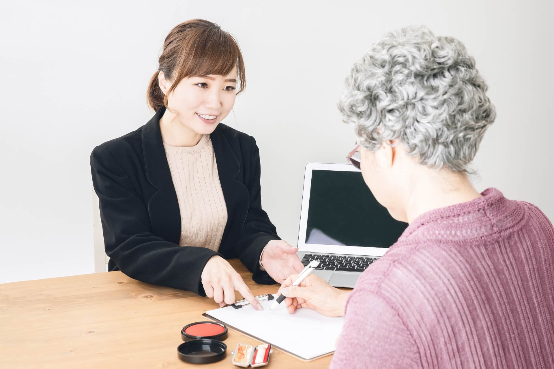 葬儀社に週買う相談と葬儀の生前予約をする高齢女性