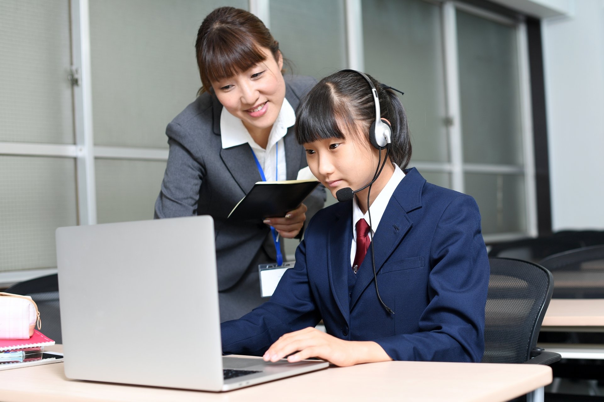 生徒にGoogleスプレッドシートの使い方を案内する教師のイメージ画像