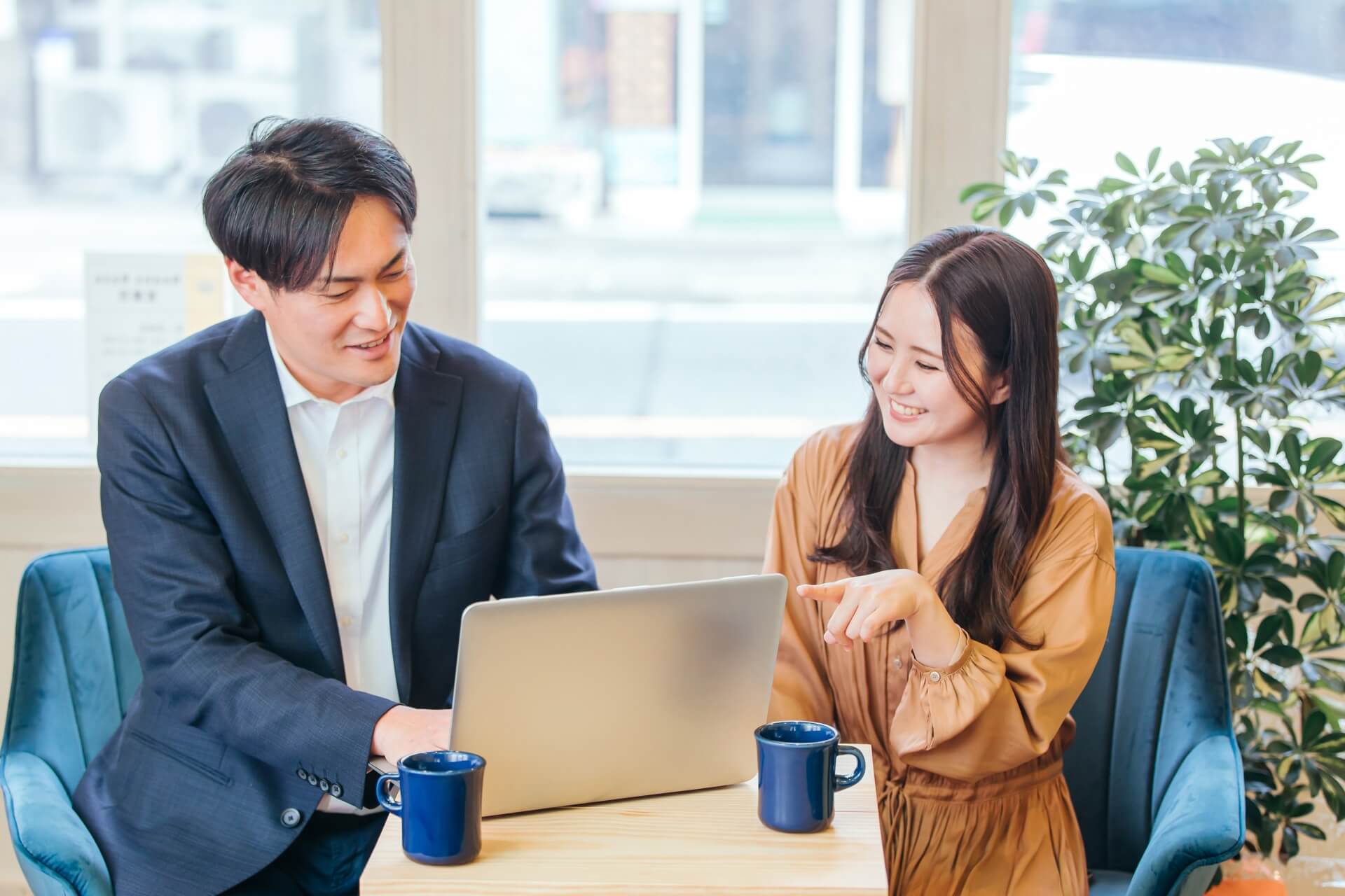 アルムナイ採用のページを作成する葬儀社の社員とアドバイスするIT業界の女性のイメージ