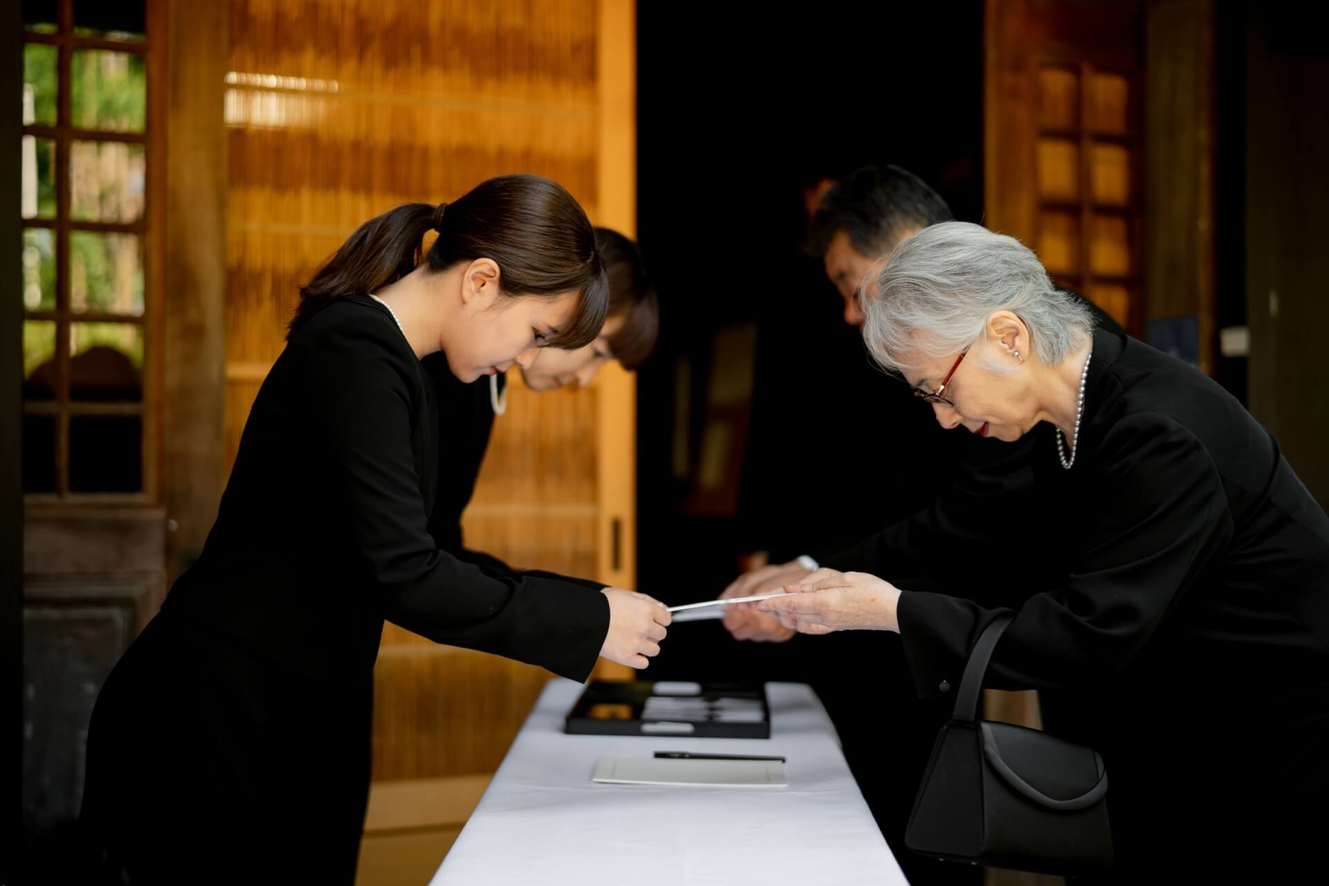 葬儀の受付で遺族の手伝いをする葬儀社スタッフのイメージ